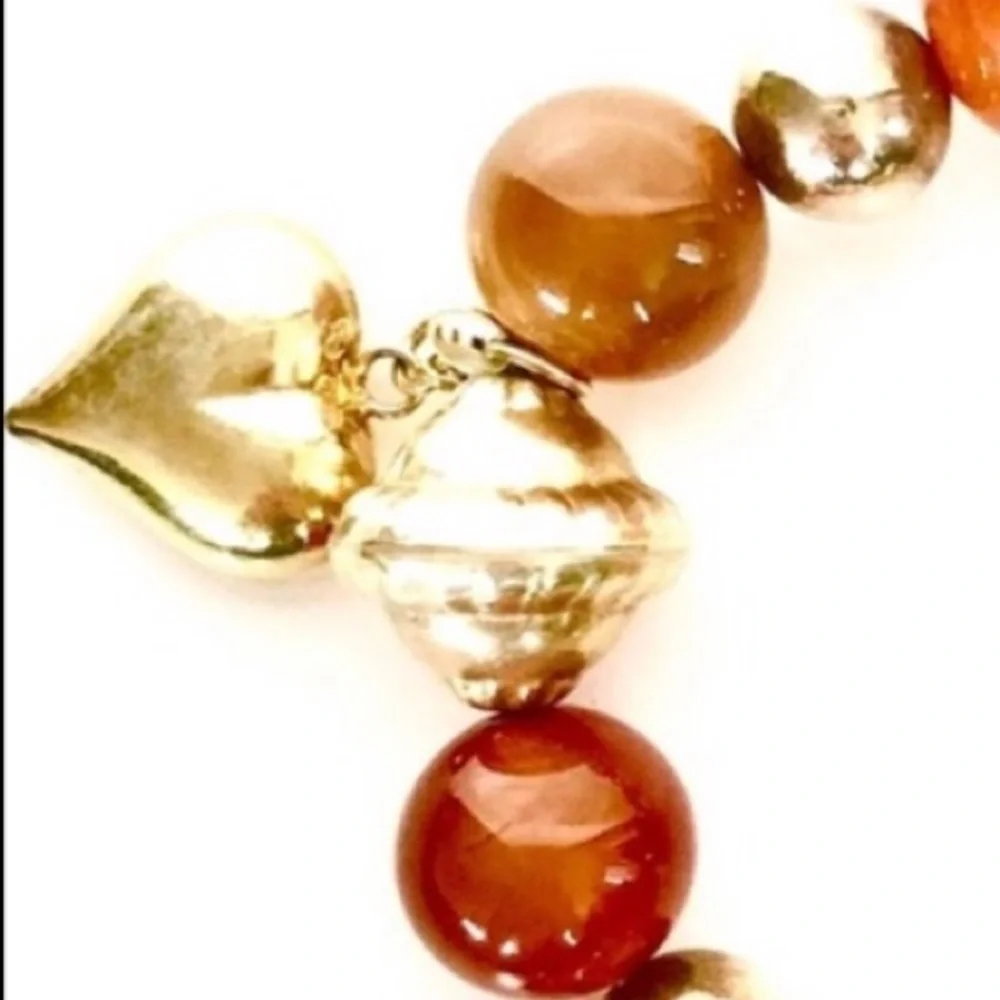 Handcrafted artisan amber tone stones paired with gold heart beaded charms brace